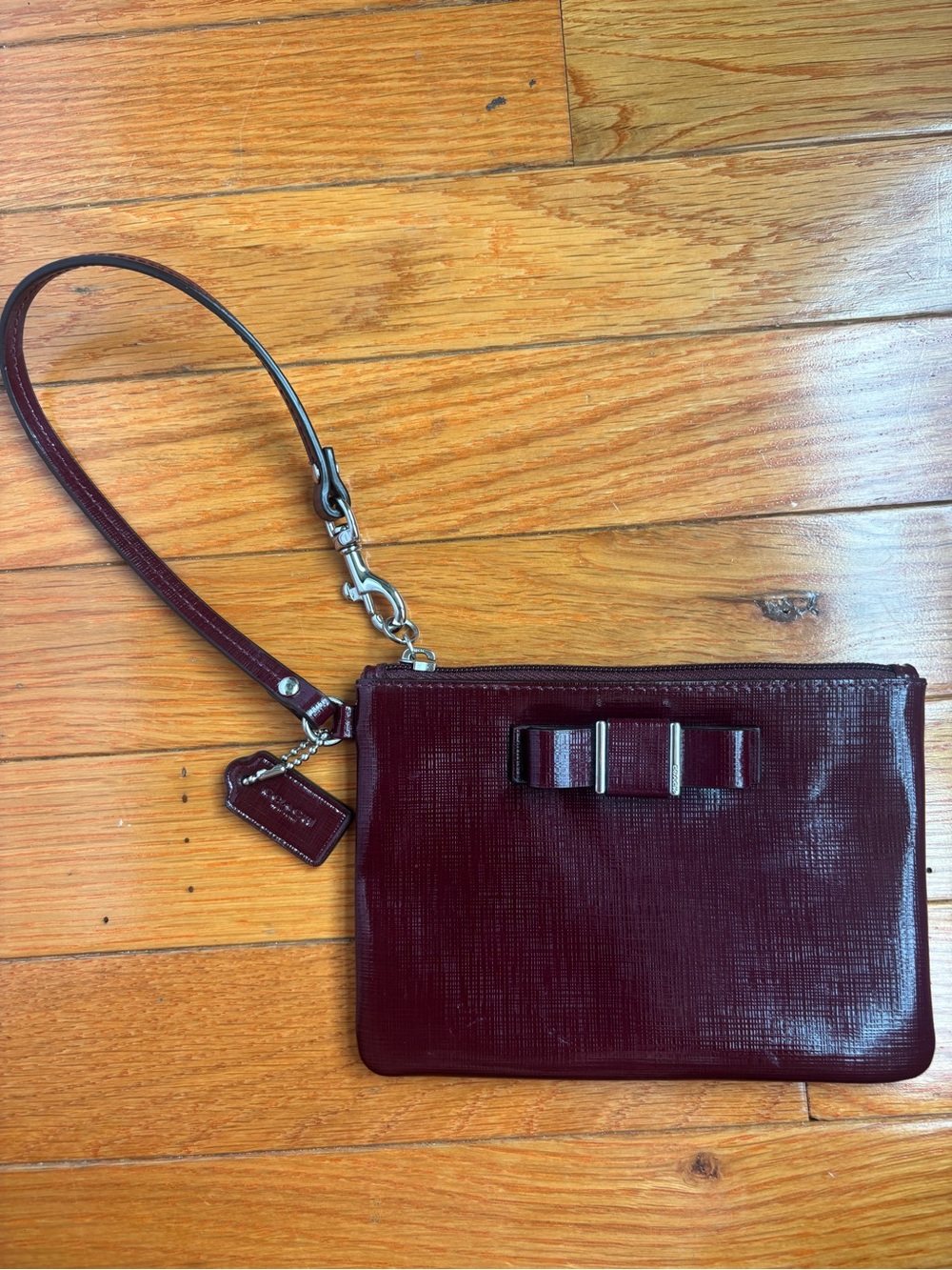 Coach Burgundy Pebbled Leather Wristlet with Bow Accent